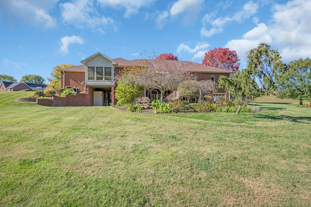 view of front facade featuring brick siding, a front lawn, and a sunroom