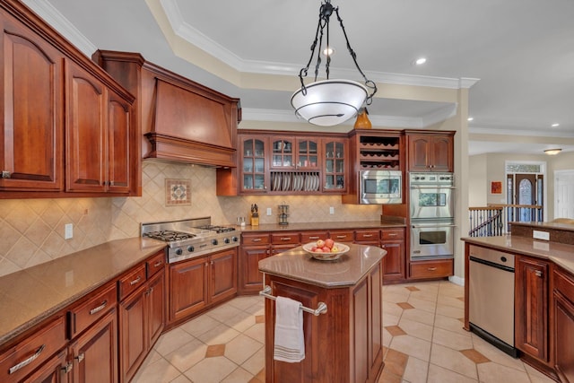 kitchen with dark stone countertops, custom exhaust hood, hanging light fixtures, glass insert cabinets, and appliances with stainless steel finishes