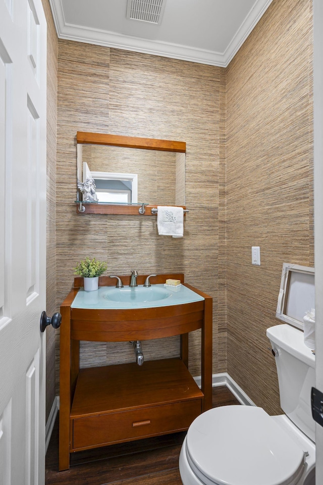 bathroom with vanity, wood finished floors, visible vents, crown molding, and toilet