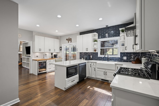 kitchen with black appliances, dark wood-style flooring, open shelves, and a sink