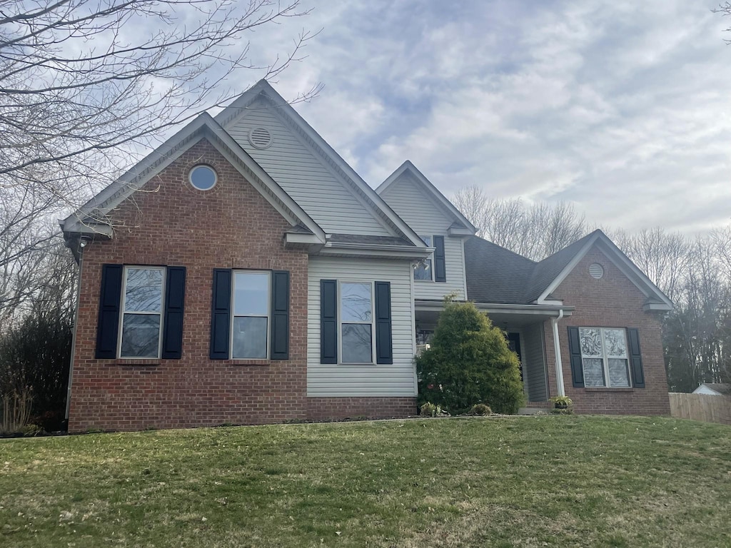 view of front of property featuring brick siding and a front yard