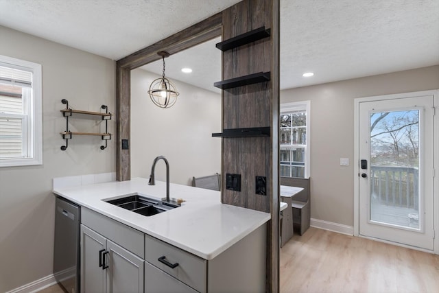 kitchen featuring gray cabinets, open shelves, a sink, a textured ceiling, and dishwasher