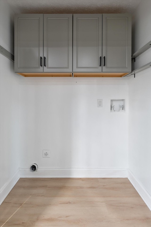 clothes washing area featuring cabinet space, hookup for an electric dryer, baseboards, and washer hookup