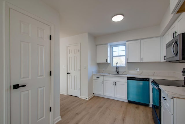 kitchen featuring dishwashing machine, a sink, electric stove, light wood-style floors, and stainless steel microwave