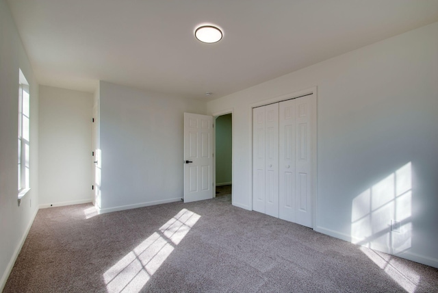 unfurnished bedroom featuring a closet, baseboards, and carpet