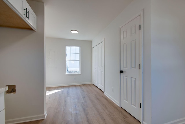 hallway with baseboards and light wood-style floors