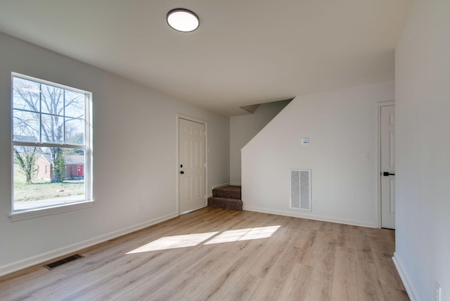 unfurnished room featuring stairway, baseboards, visible vents, and light wood finished floors