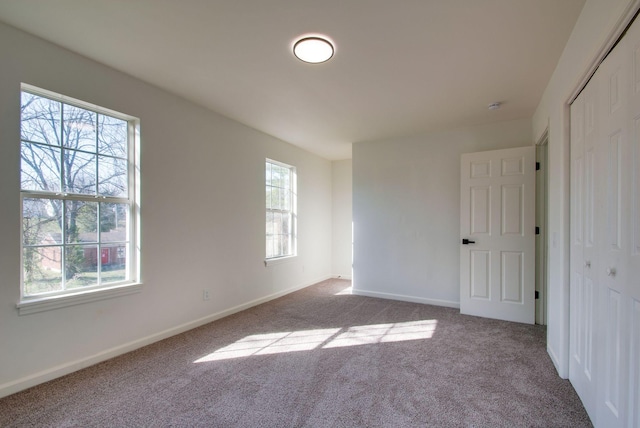 unfurnished bedroom with carpet flooring, baseboards, and a closet