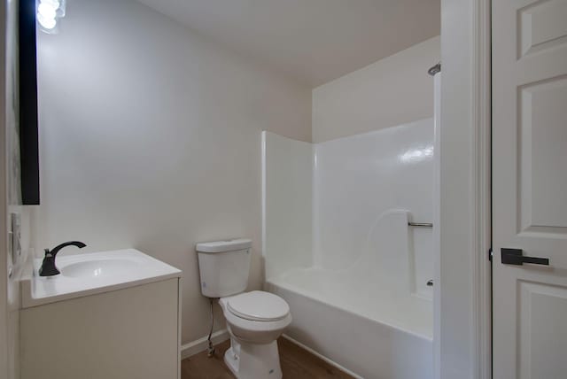 full bathroom featuring vanity, wood finished floors, washtub / shower combination, baseboards, and toilet