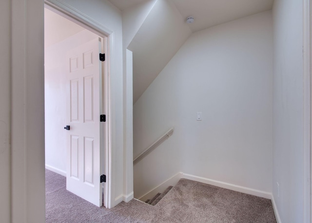 staircase featuring carpet flooring, lofted ceiling, and baseboards