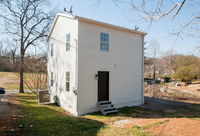 back of property featuring entry steps, cooling unit, and crawl space