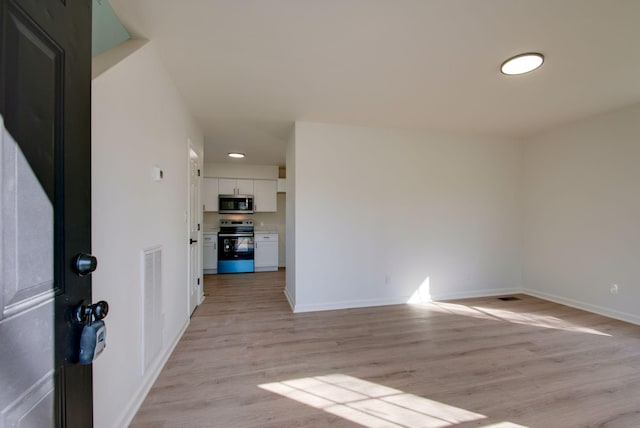 unfurnished room featuring visible vents, baseboards, and light wood-style flooring