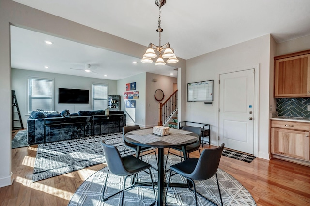 dining room with recessed lighting, baseboards, stairs, and light wood finished floors