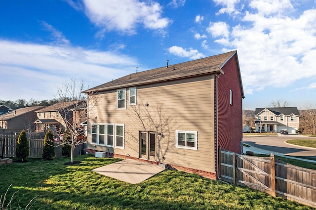 back of house with a patio, a yard, fence, and a residential view