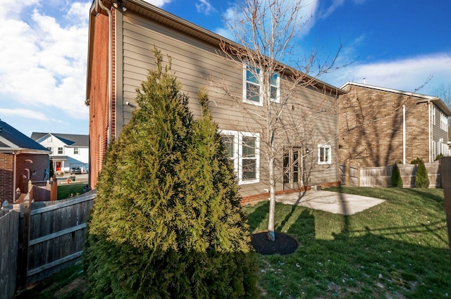 back of property featuring a yard, fence, and a patio area