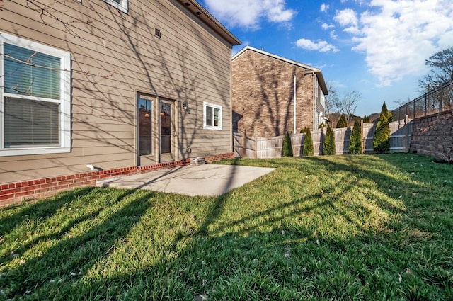 rear view of property featuring a yard, a patio, and fence