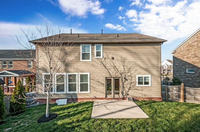 back of property featuring a patio, a lawn, fence, and roof with shingles