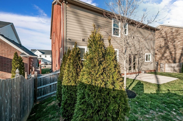 rear view of house with a patio, a lawn, and fence