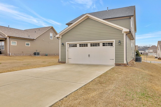 view of side of home featuring a garage, a yard, driveway, and central AC