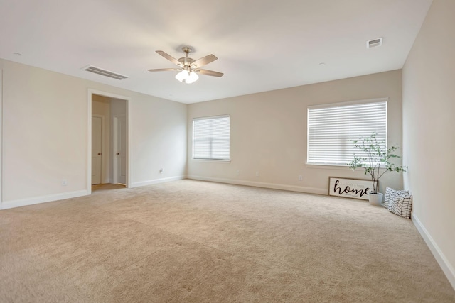 spare room featuring visible vents, baseboards, carpet, and a ceiling fan