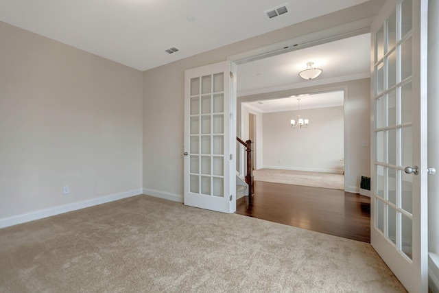 spare room featuring french doors, baseboards, visible vents, and ornamental molding