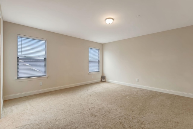 unfurnished room with baseboards and carpet