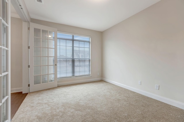 spare room featuring french doors, baseboards, and carpet floors