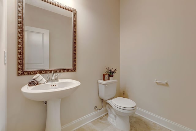 bathroom featuring tile patterned floors, toilet, and baseboards