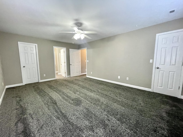 unfurnished bedroom with visible vents, baseboards, ceiling fan, and dark carpet