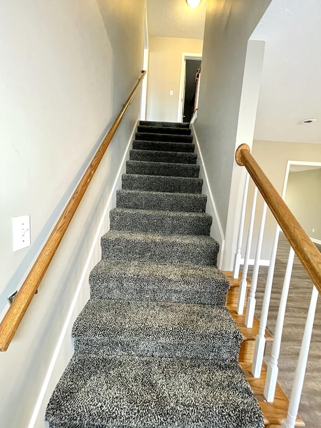 staircase with wood finished floors and baseboards