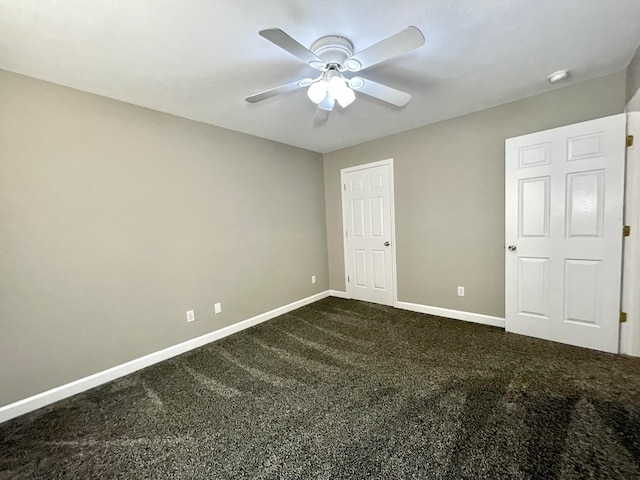 unfurnished bedroom with baseboards, a ceiling fan, and dark carpet