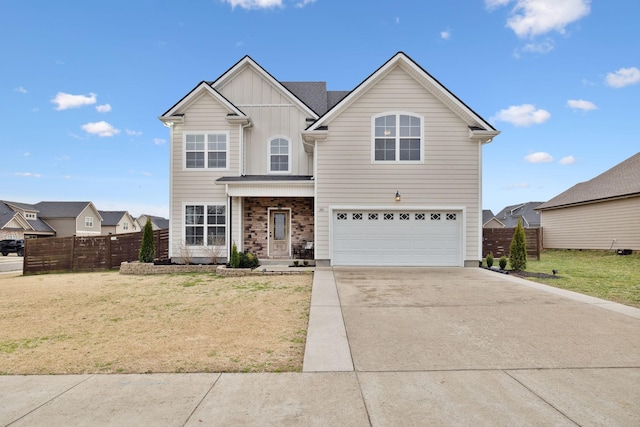 traditional home with a front yard, concrete driveway, an attached garage, and fence