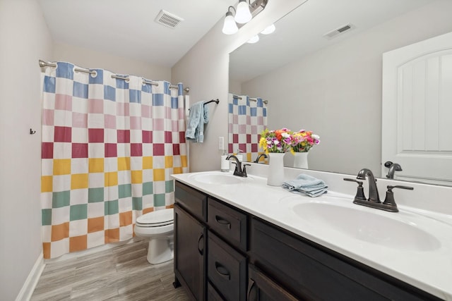 full bathroom with visible vents, toilet, and a sink