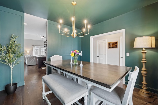 dining space with dark wood-type flooring and a notable chandelier