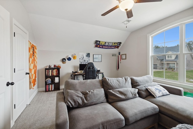 living area with carpet flooring, baseboards, ceiling fan, and vaulted ceiling