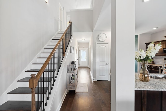 stairway featuring baseboards and wood-type flooring