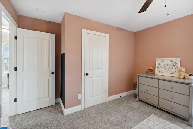 bedroom with a ceiling fan, light colored carpet, and baseboards