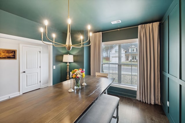 dining area with visible vents, baseboards, a notable chandelier, and dark wood finished floors