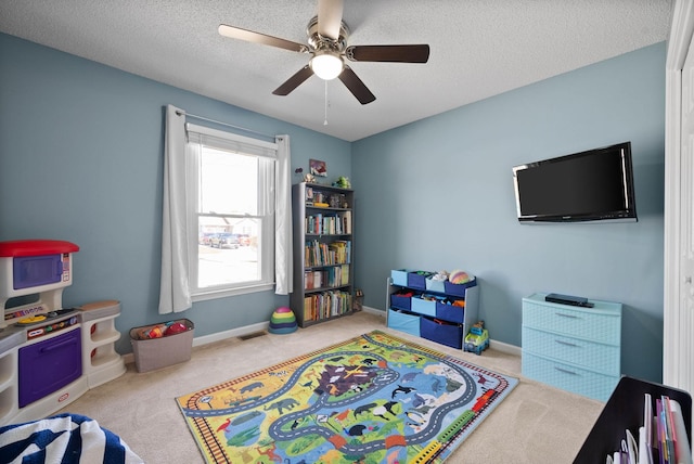 rec room featuring visible vents, baseboards, carpet flooring, a textured ceiling, and a ceiling fan