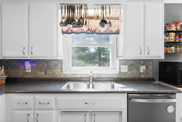 kitchen featuring a sink, stainless steel dishwasher, dark countertops, and white cabinets