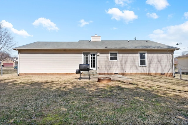 rear view of house with fence, a yard, a chimney, crawl space, and a patio area