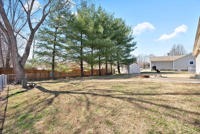 view of yard featuring a storage shed, an outdoor structure, and fence