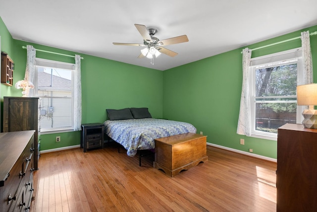 bedroom featuring ceiling fan, baseboards, and wood-type flooring