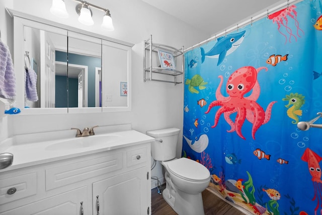 bathroom featuring vanity, a shower with shower curtain, toilet, and wood finished floors