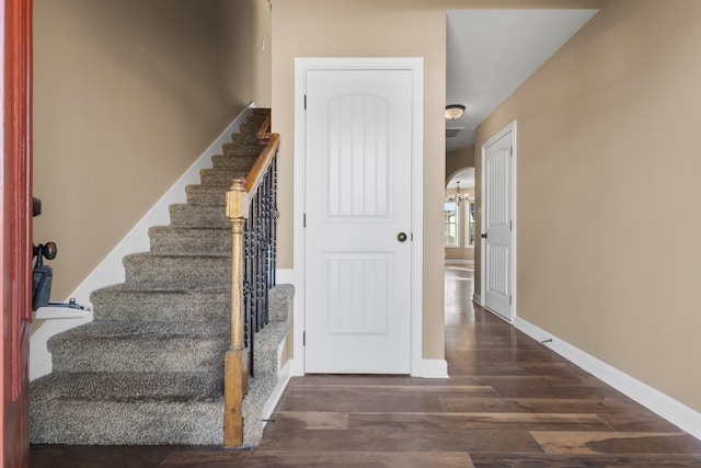 stairway with visible vents, wood finished floors, and baseboards