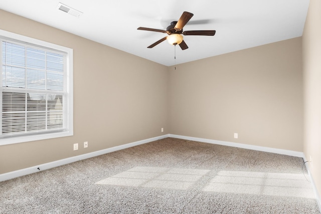 empty room with baseboards, carpet, visible vents, and ceiling fan