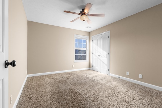 unfurnished bedroom featuring a ceiling fan, carpet, visible vents, baseboards, and a closet