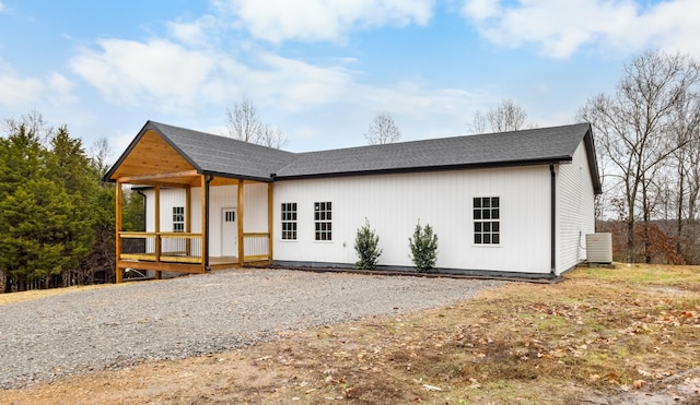 modern farmhouse style home with a shingled roof and central AC