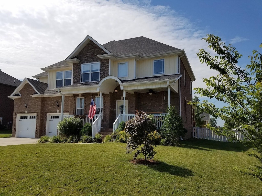 craftsman house featuring driveway, fence, covered porch, a front yard, and a garage