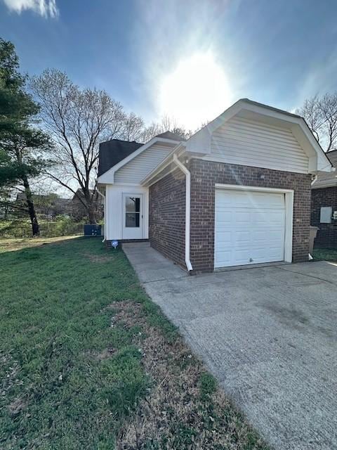 view of home's exterior with brick siding, a yard, concrete driveway, and a garage